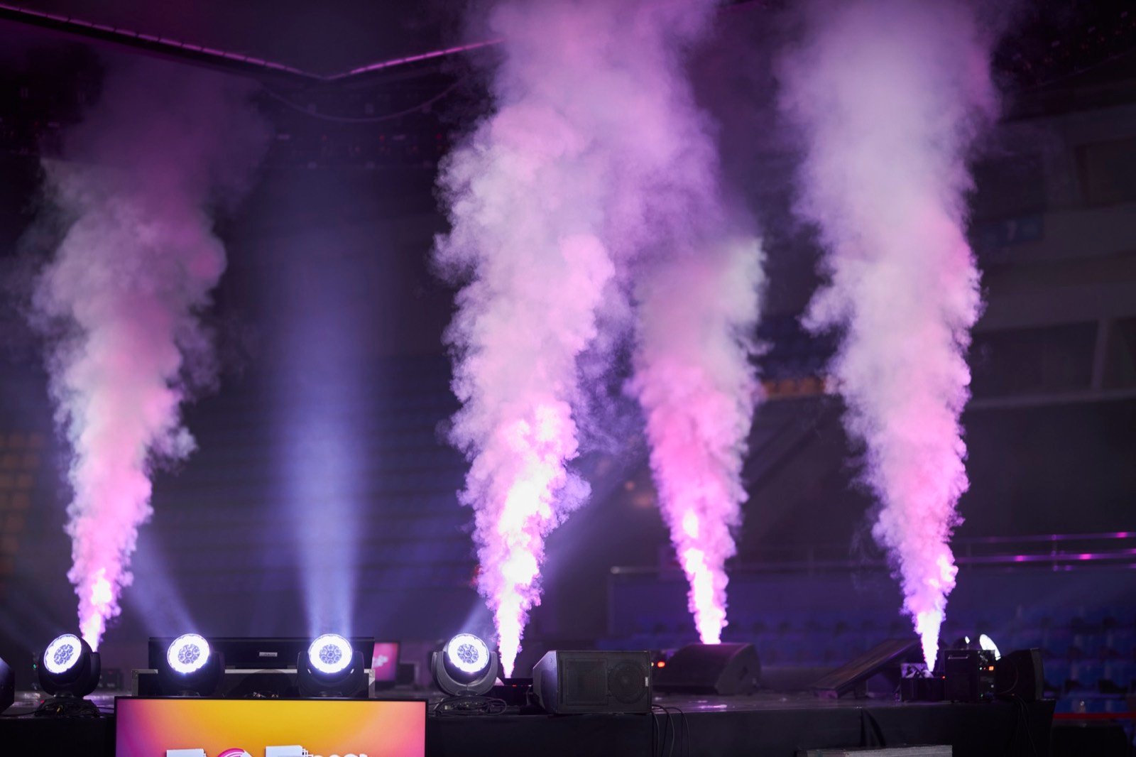 Purple smoke effects rising across a festival stage